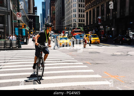 New York City, USA - 21. Juni 2018: Radfahrer reiten durch die 8th Avenue gegen Stadtbild Stockfoto