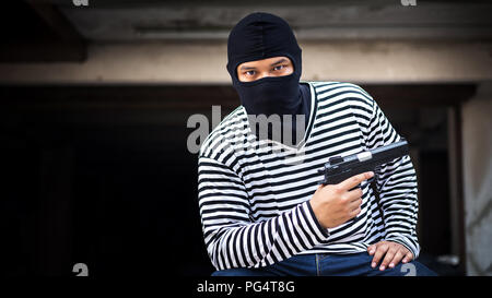 Dieb oder Mord halten Pistole Pistole und Blick auf das Ziel für die Geld an gefährlichen Bereich in einem Konzept des Lebens, Dieb, Geld Stockfoto