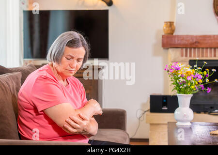 Ältere Frau mit Schmerzen in der Hand zu Hause. Alter, Gesundheit Problem und Personen Konzept Stockfoto