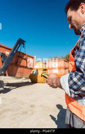 Mann Laden von Bauschutt Container auf Lkw Stockfoto