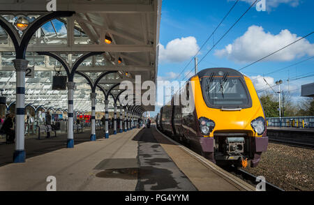 Klasse 220 Voyager Personenzug in länderübergreifende Livree auf einer Plattform auf einem Bahnhof auf der East Coast Main Line, England. Stockfoto