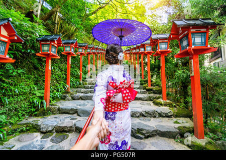 Frau in der Hand des traditionellen japanischen kimono Holding Mensch und was ihn zu Kifune Schrein, Kyoto in Japan. Stockfoto