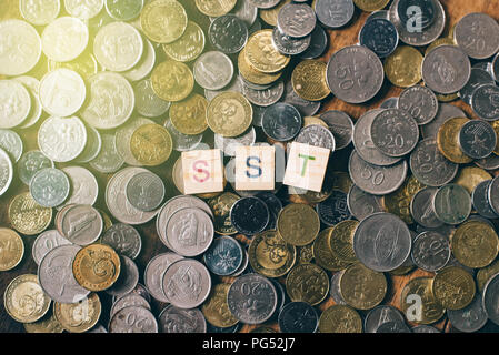 SST alphabet Fliese über Haufen der malaysische Währung Münzen, Steuerfragen Stockfoto