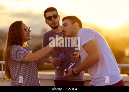 Drei attraktive Freunde Spaß haben auf dem Balkon bei Sonnenuntergang Stockfoto