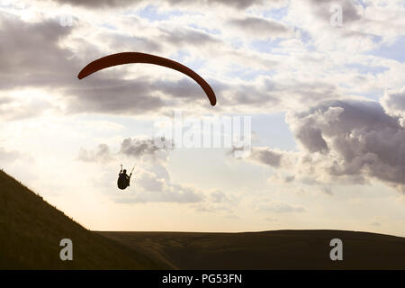 Ein Gleitschirm ist gegen den Himmel über Edale Tal im Peak District, Derbyshire. Die Piloten gelangen von der starken Aufwind, dass Trade Boxes Stockfoto