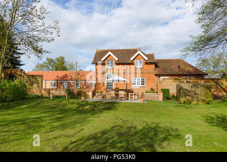 Viktorianische ehemaliger Trainer Haus und Stallungen mit Garten und Terrasse. Das historische Gebäude wurde in ein modernes Haus der Familie umgewandelt. Stockfoto