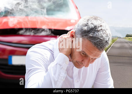 Nahaufnahme eines reifen Menschen leiden unter Nackenschmerzen Vor einer Panne Auto Stockfoto