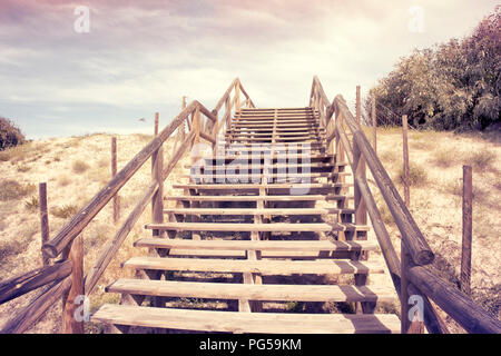 Alte Holztreppe auf Sanddünen zu Aufstieg in den Himmel. Stockfoto