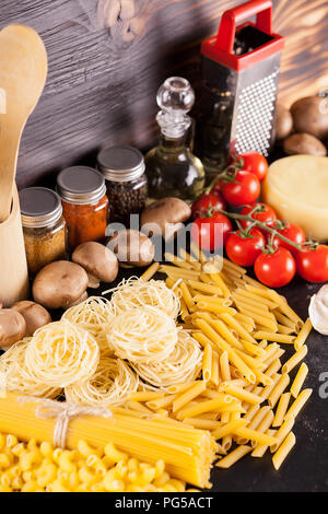 Italienische Küche aus raw Teigwaren neben frischem Gemüse, verschiedene Arten von Gewürzen und Sonnenblumenöl Stockfoto