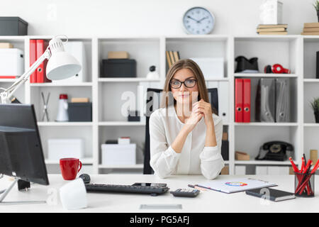 Ein junges Mädchen sitzt am Computer Schreibtisch im Büro. Stockfoto