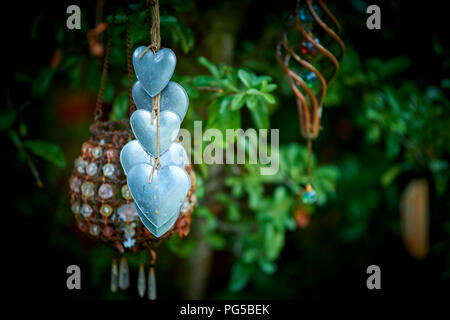 Hängende herzförmige Ornamente in einem hübschen Garten Stockfoto