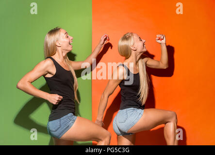 Gerne Frauen gehen, marschieren und lächelnd auf Studio Hintergrund isoliert. Schöne weibliche Brustbild. Junge emotionale Frauen. Die menschlichen Gefühle, Mimik Konzept. Vorderansicht. Stockfoto