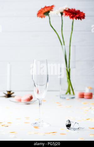 Selektiver Fokus leere Glas mit Blumenstrauß aus Gerbera Blumen auf grauem Hintergrund Stockfoto