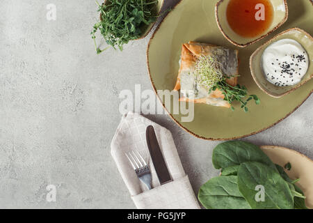 Die Zusammensetzung von Lebensmitteln mit Samosas in griescreme Teig gefüllt mit Spinat und Paneer dekoriert mit gekeimten Samen von Luzerne und Sonnenblumen auf dem Teller serviert. Stockfoto