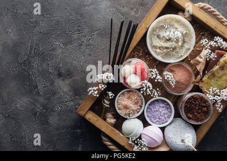 Blick von oben auf die Spa und Bad Accessoires im Holzkasten auf grauem Hintergrund Stockfoto