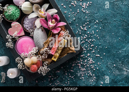 Blick von oben auf die brennende Kerzen, handgemachte Seifen und organische Spa Zubehör mit Blumen Stockfoto