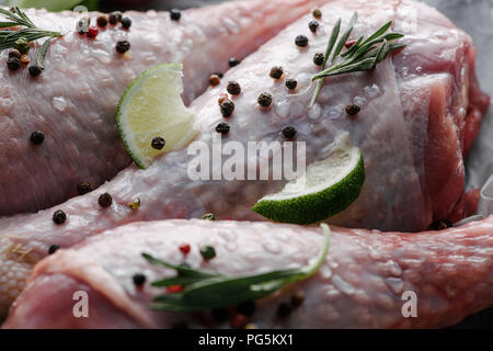 Nahaufnahme Blick auf raw Hähnchenschenkel mit Pfefferkörner, Rosmarin und Kalk Stockfoto