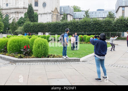 Touristen fotografieren in Festival Gärten von St. Pauls Kirchhof in der Londoner City Stockfoto