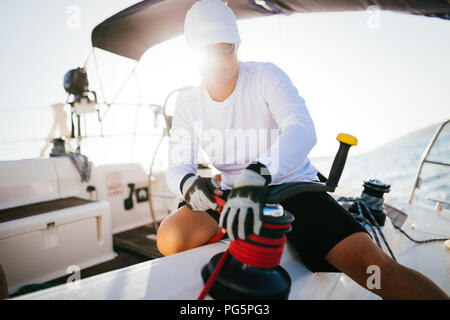 Attraktive starke Frau Segeln mit Ihrem Boot Stockfoto