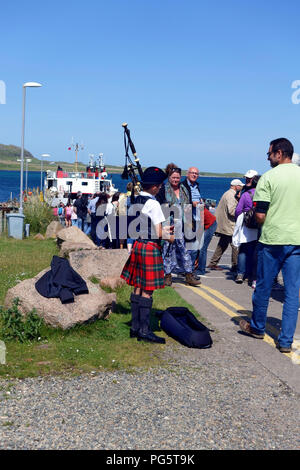 Junge Piper unterhaltsam die Calmac Fähre queuing Passagiere zu Iona in Fionnphort auf der Isle of Mull Stockfoto