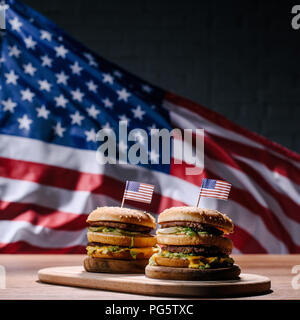 Leckere Burger auf Holz Schneidebrett vor winken United States flag Stockfoto