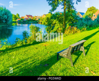 Kleine Bank aus Holz in einem schönen Park mit See Landschaft Stockfoto