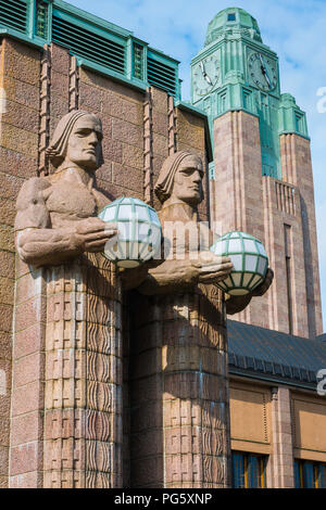 Helsinki Art Nouveau, Blick auf zwei riesige Granitstatuen (die Steinmänner) mit Globenlampen am Eingang zum Bahnhof Helsinki, Finnland Stockfoto