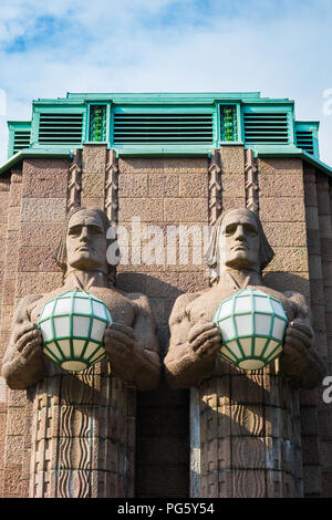 Helsinki Hauptbahnhof, Blick auf zwei riesige Granitstatuen mit Globenlampen am Eingang zum Helsinki Hauptbahnhof, Finnland. Stockfoto