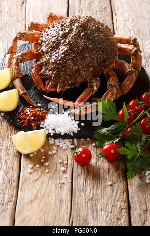 Vorbereitung für das Kochen Seespinne mit frischen Zutaten close-up auf einem Holztisch. Vertikale Stockfoto