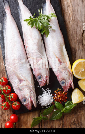 Raw Gabeldorsch oder mostella Fisch mit Zutaten close-up auf den Tisch. Vertikal oben Ansicht von oben Stockfoto