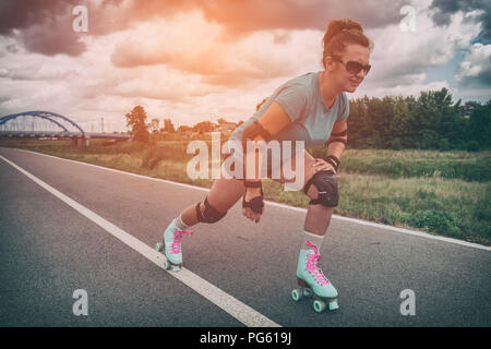 Frau, die in einem Jahrgang Rollschuhe, retro Quad skates Reiten im Freien. Stockfoto