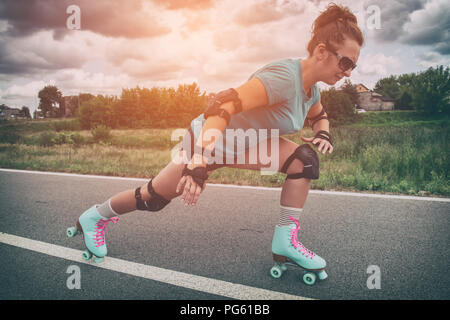 Frau, die in einem Jahrgang Rollschuhe, retro Quad skates Reiten im Freien. Stockfoto