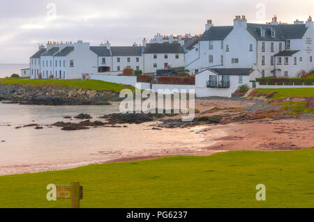 Port Charlotte, und der Port Charlotte Hotel, neben einem Sandstrand mit Felsen und Gras umgeben. Stockfoto