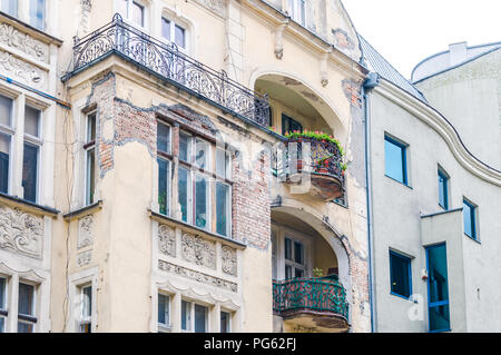 Ein baufälliges Gebäude mit Balkonen und fehlende Putz mit freiliegenden Mauerwerk in Poznań (Posen), Polen Stockfoto