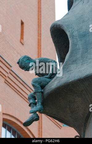 Eine kleine Abbildung eines Mannes über eine Kante gelehnt, ein Detail aus einem Metall Kunstwerk das Stary Browar in Poznań (Posen), Polen Stockfoto