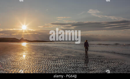 Einsame Abbildung zu Fuß auf Sunset Beach Stockfoto