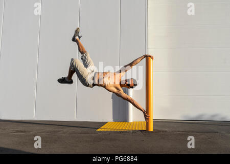 Acrobat Schulung auf einem Pfosten Stockfoto