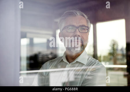 Porträt der Geschäftsmann aus Fenster Stockfoto