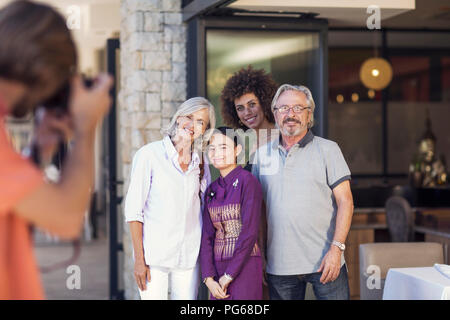 Familie, die Bilder mit asiatischen Kellnerin vor dem Restaurant Stockfoto