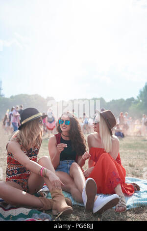 Junge Leute sitzen auf Decke im Music Festival Stockfoto