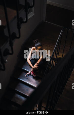 Schöne junge Frau in Treppe sitzen im Sonnenlicht Stockfoto