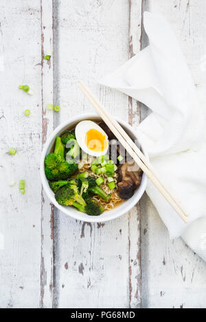 Schüssel mit Ramen Suppe mit Ei, Brokkoli, Nudeln, Shitake Pilzen und Frühlingszwiebeln Stockfoto