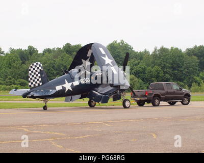 Corsair Warbird aus dem 2. Weltkrieg bereitet sich auf die Flugshow am Flughafen West Milford, NJ vor. Das Flugzeug wird mit eingeklappten Flügeln abgeschleppt. Stockfoto