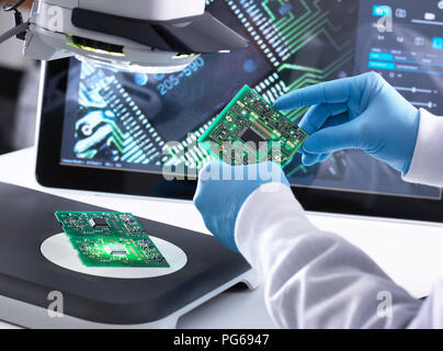 Techniker mit Hilfe eines 3-D Stereo Mikroskop für die Qualitätskontrolle in der Herstellung von Platinen für die Elektronikindustrie Stockfoto