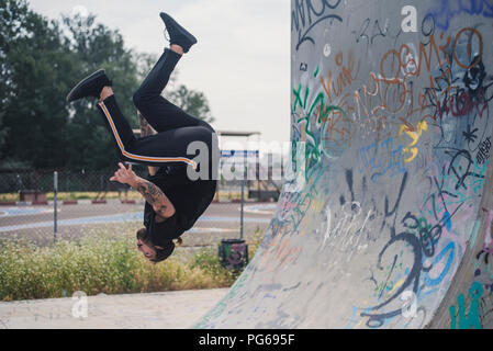Tätowierten Mann tun Parkour in einem Skatepark Stockfoto
