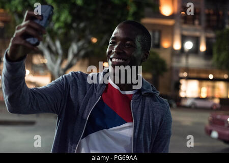Lächelnden jungen Mann eine selfie bei Nacht Stockfoto