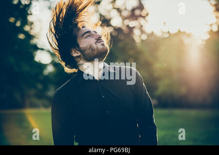 Heavy Metal Fan Headbangen in einem Park Stockfoto