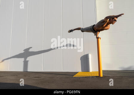 Acrobat Schulung auf einem Pfosten Stockfoto