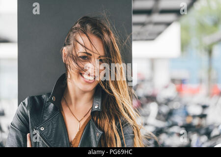 Porträt der glückliche junge Frau mit windswept Haar Stockfoto