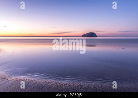 Großbritannien, Schottland, East Lothian, North Berwick, Erhabene, Blick auf Bass Rock (weltberühmten Gannet Kolonie) bei Sonnenuntergang, Leuchtturm, lange Belichtung Stockfoto